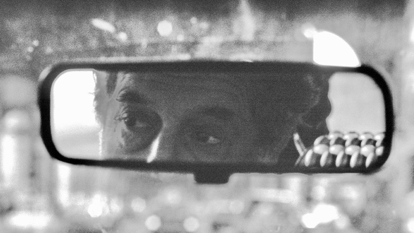 Die Augen eines Mannes im Rückspiegel eines Autos